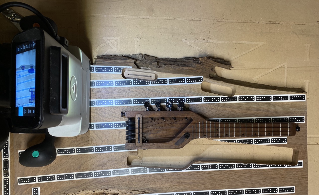 Tanya's finished ukulele with the wood slab and CNC router with which it was cut